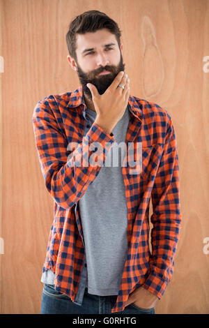Thoughtful hipster touching his chin Stock Photo
