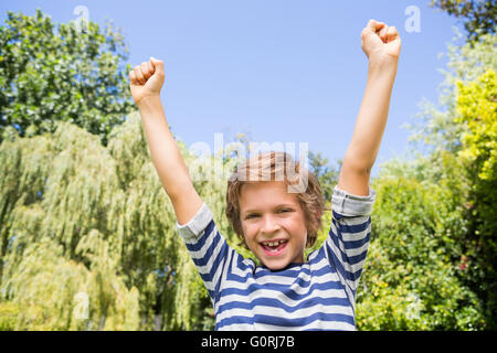 Portrait of happy boy raising arms Stock Photo