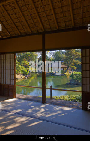 A naturally-lit interior view shows the traditional tatami mat floors, bamboo ceiling, and shoji paper-and-wood sliding doors of Geppa-ro tea pavilion, and looks across the garden pond to Shoi-ken tea pavilion at Katsura Imperial Villa, in the southwest a Stock Photo