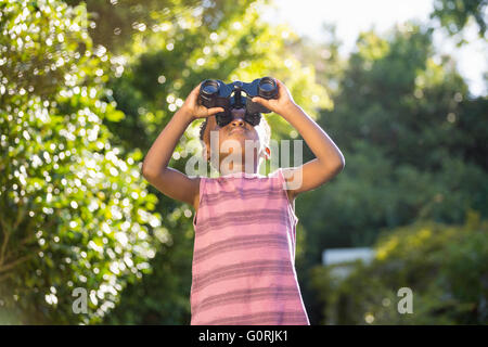 Boy looking through binoculars Stock Photo