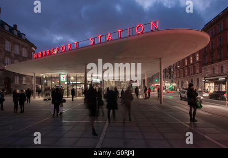 Norreport Station, Denmark. The new Norreport station is composed of a series of rounded, floating roofs, mounted on glass pavilions. View of neon sign of the station's name. People walking and standing outside of the station in the city centre. Stock Photo