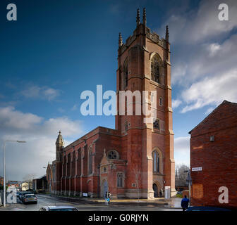 All Souls, Bolton, England. Exterior view of the church and its tower. A few people and cars in the street. Stock Photo