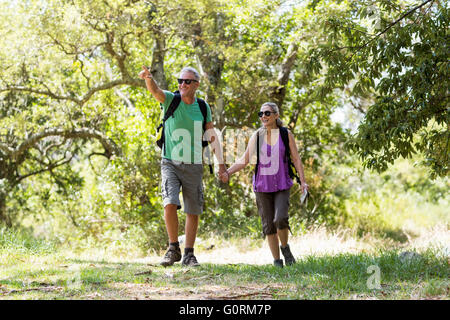 Couple pointing and holding hands each other during a hike Stock Photo