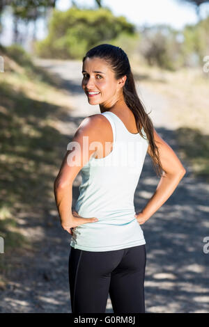 Woman runner front the back smiling and turning around to the camera Stock Photo