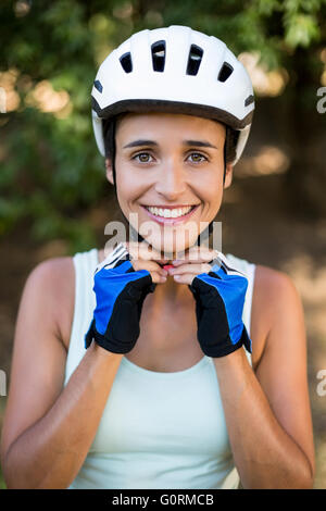 Woman smiling and fastening her cycling helmet