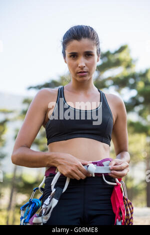 Woman unsmiling with climbing equipment Stock Photo