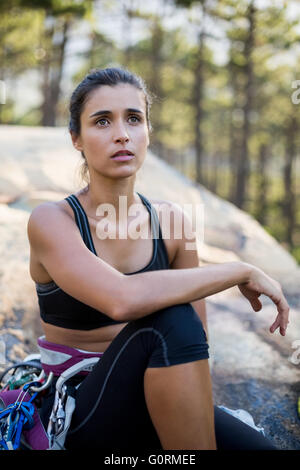 Woman sitting and posing with climbing equipment Stock Photo