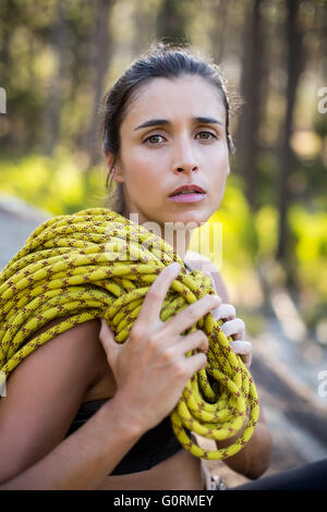 Woman unsmiling and sitting with climbing equipment Stock Photo