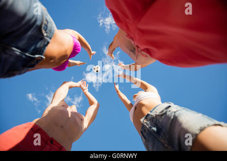 Low angle view of friends playing with a ball Stock Photo