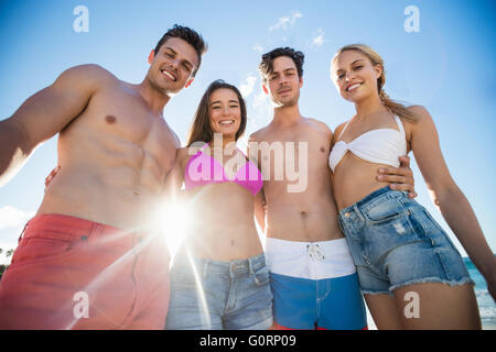 Smiling friends standing at the beach Stock Photo