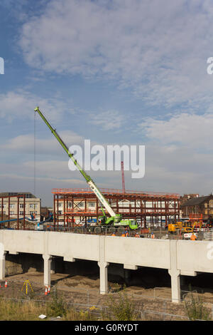 Construction work in progress on the new Bolton bus interchange with a mobile crane lifting sections of steelwork into place. Stock Photo