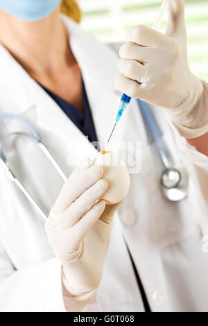 Female researcher/doctor inoculating flu virus into chicken eggs. Stock Photo