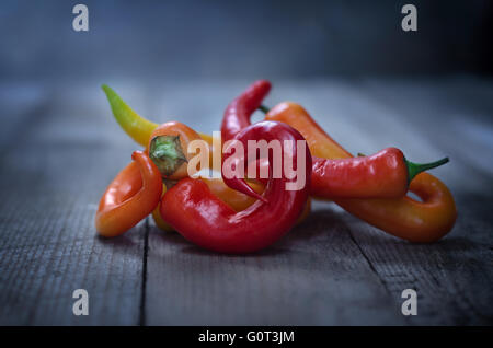 Colorful chili peppers on old wooden background. Stock Photo