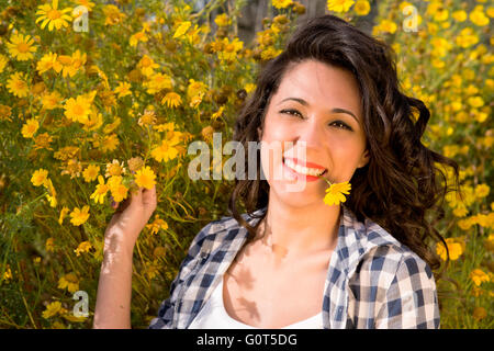 portrait of fascinating girl having fun among flowers in spring meadow Stock Photo
