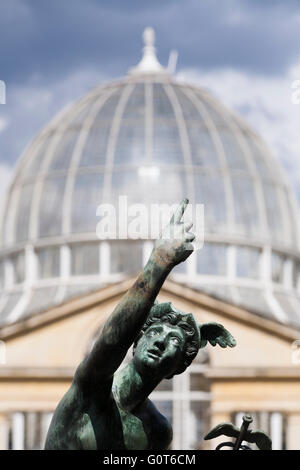 Statue of winged Mercury and Syon House Great Conservatory glass dome (Grade I listed building) in formal garden / gardens. UK Stock Photo
