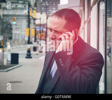 A business man is wearing a super hero blue costume with a suit in a city for a career success or innovation concept. Stock Photo