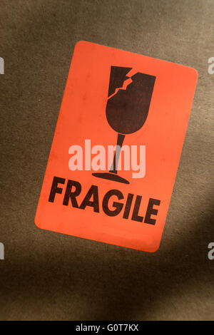Bright Orange and Black Fragile Sticker on a Cardboard Mailing Box, USA Stock Photo