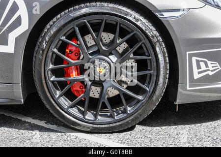 Red disc brake calipers on the front wheel of a Porsche Targa 4S. Stock Photo