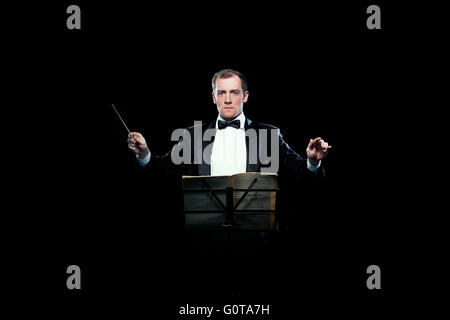 Studio photo of music conductor holding his baton Stock Photo