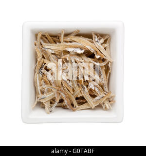 Dried anchovies in a square bowl isolated on white background Stock Photo