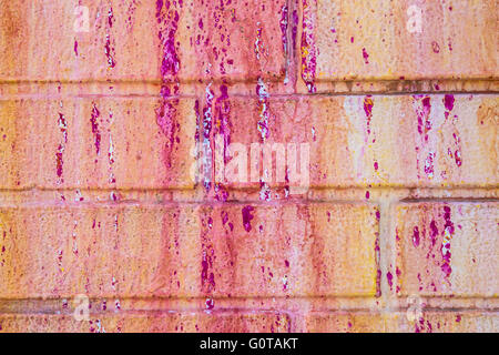 Grunge painted brick wall with pink and orange paint Stock Photo