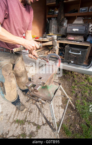 Farrier Hot Shoeing a Horse in a stable yard Stock Photo