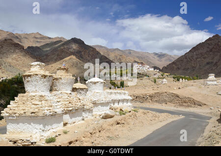 Buddhist Chortens in the foreground and Likir Monastery in the background, situated in a typical Ladakh landscape, near Leh, Ind Stock Photo