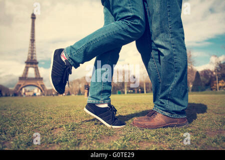 Retro photo of feet of couple kissing near Eiffel tower Stock Photo