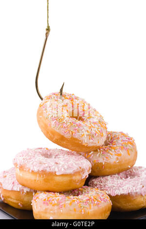 Donuts in a pile being hooked on a white background Stock Photo