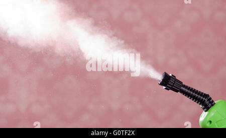 Closeup steam exiting nozzle of vapor cleaning machine, pink background Stock Photo