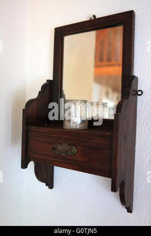 Old vintage antique wooden mirror on a wall in a bedroom in a cottage in Ireland Stock Photo