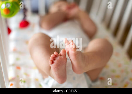 Baby boy lying on crib sleeping in bedroom Stock Photo