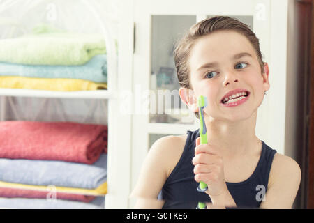 Portrait of a Boy brushing his teeth in bathroom Stock Photo