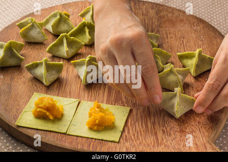 Woman preparing stuffed pumpkin saccottini pasta Stock Photo