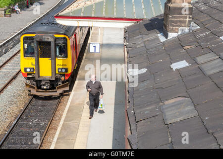 Person leaving a train walking along a platform at Matlock Railway Station, Derbyshire, England, UK Stock Photo