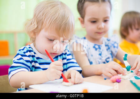 Plasticine modeling clay in children class. Teacher teaches in school.  Stock Photo by ©poznyakov 169359466