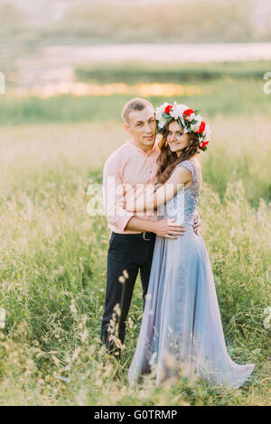 Couple of young happy people embracing in the meadow. Stock Photo
