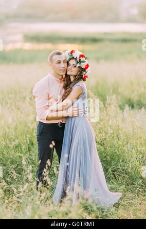 Couple of young happy people embracing in the meadow. Stock Photo