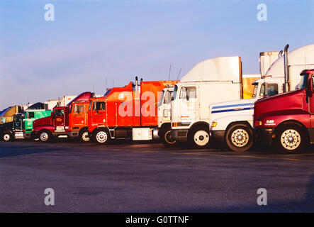 Parked tractor trailer trucks lined up at truck stop rest area