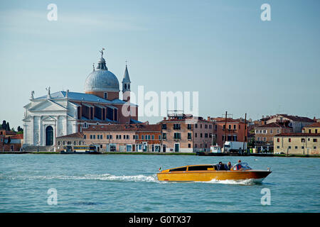 Redentore Church and boat on canal, Venice, Italy Stock Photo