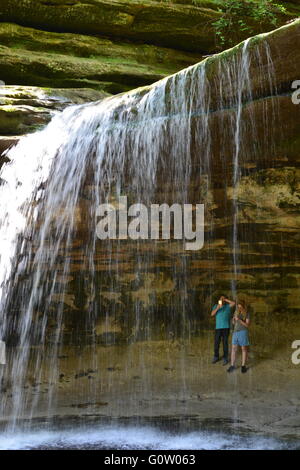Hikers at the sandstone cliff waterfall in La Salle Canyon at Starved Rock State Park on the banks of the Illinois River. Stock Photo