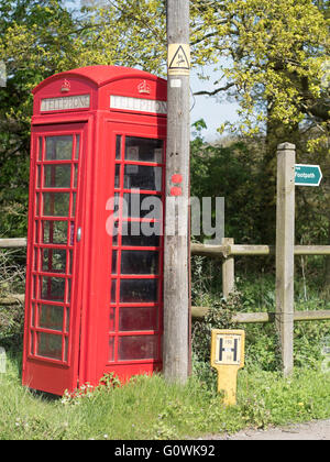 An old-style traditional British red telephone box in a rural setting. Stock Photo