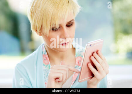 Girl reading message on her iPhone Stock Photo