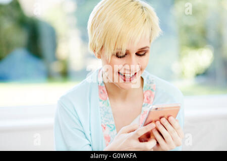 Girl reading message on her iPhone Stock Photo