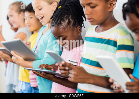 Close up view of pupils standing using tablet pc Stock Photo