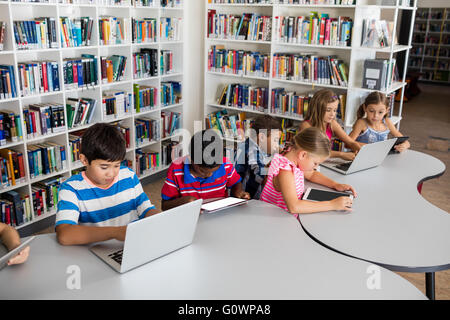 Side view of pupil using laptop and tablet pc Stock Photo