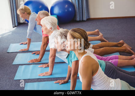 Seniors and fitness instructor stretching their legs Stock Photo