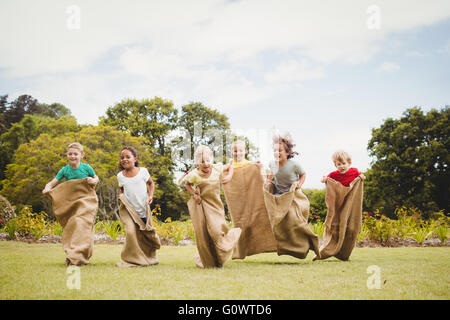 Children having a sack race in park Stock Photo