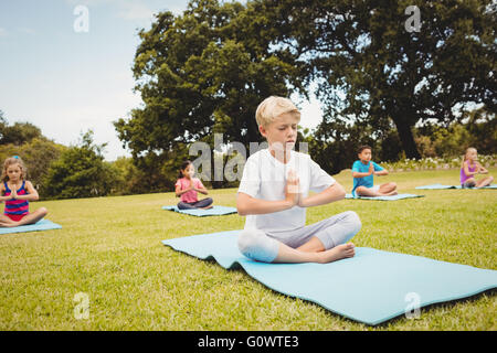 Side view of children doing yoga Stock Photo