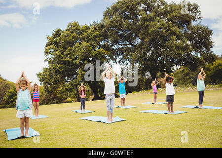 Children standing and doing yoga Stock Photo